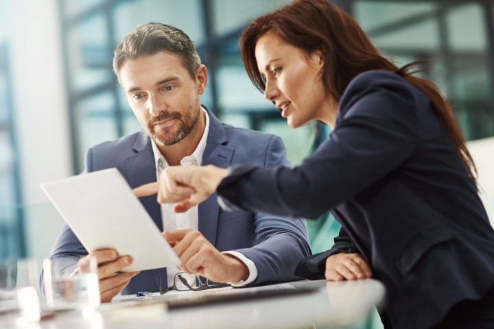 woman and man looking at work on a tablet